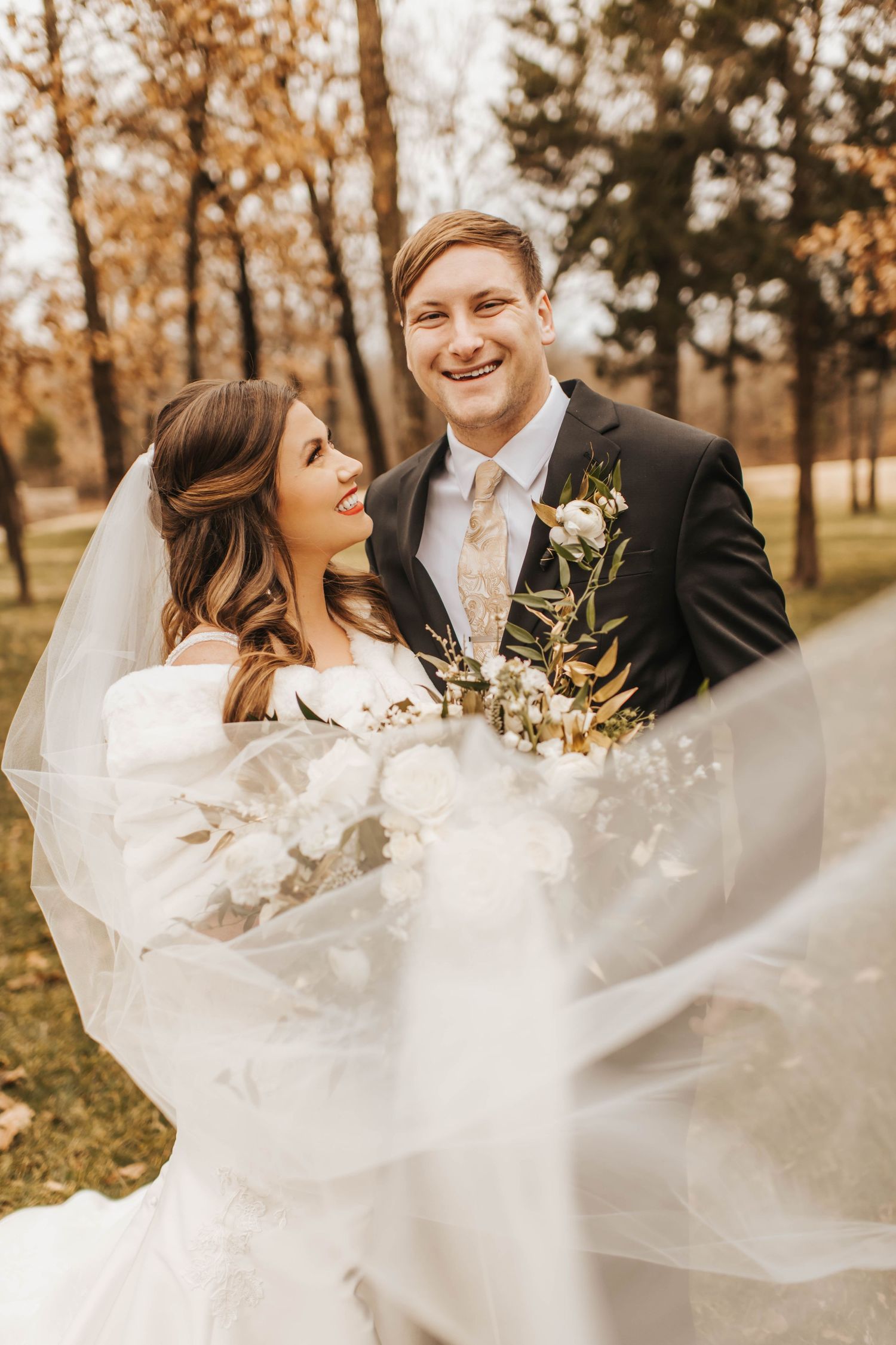 Smiling bride and groom with a wedding veil