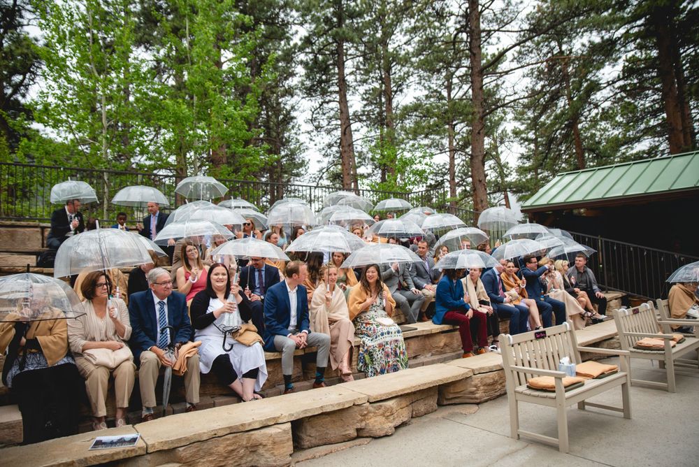 Guests under umbrellas during rainy ceremony