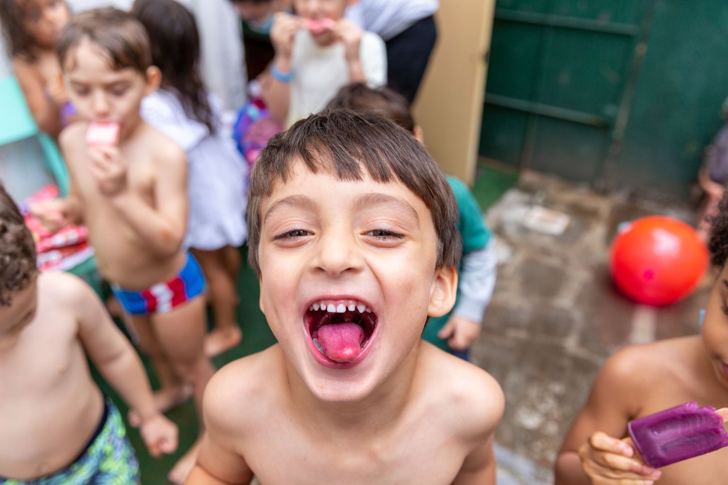 Joyful candid photo of children playing and laughing outdoors in summer.