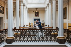 couple in wedding attire in Brighton Town Hall leaning back and looking into each others eyes