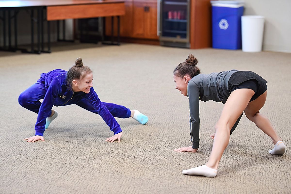 Smiling rhythmic gymnasts in performance workshop
