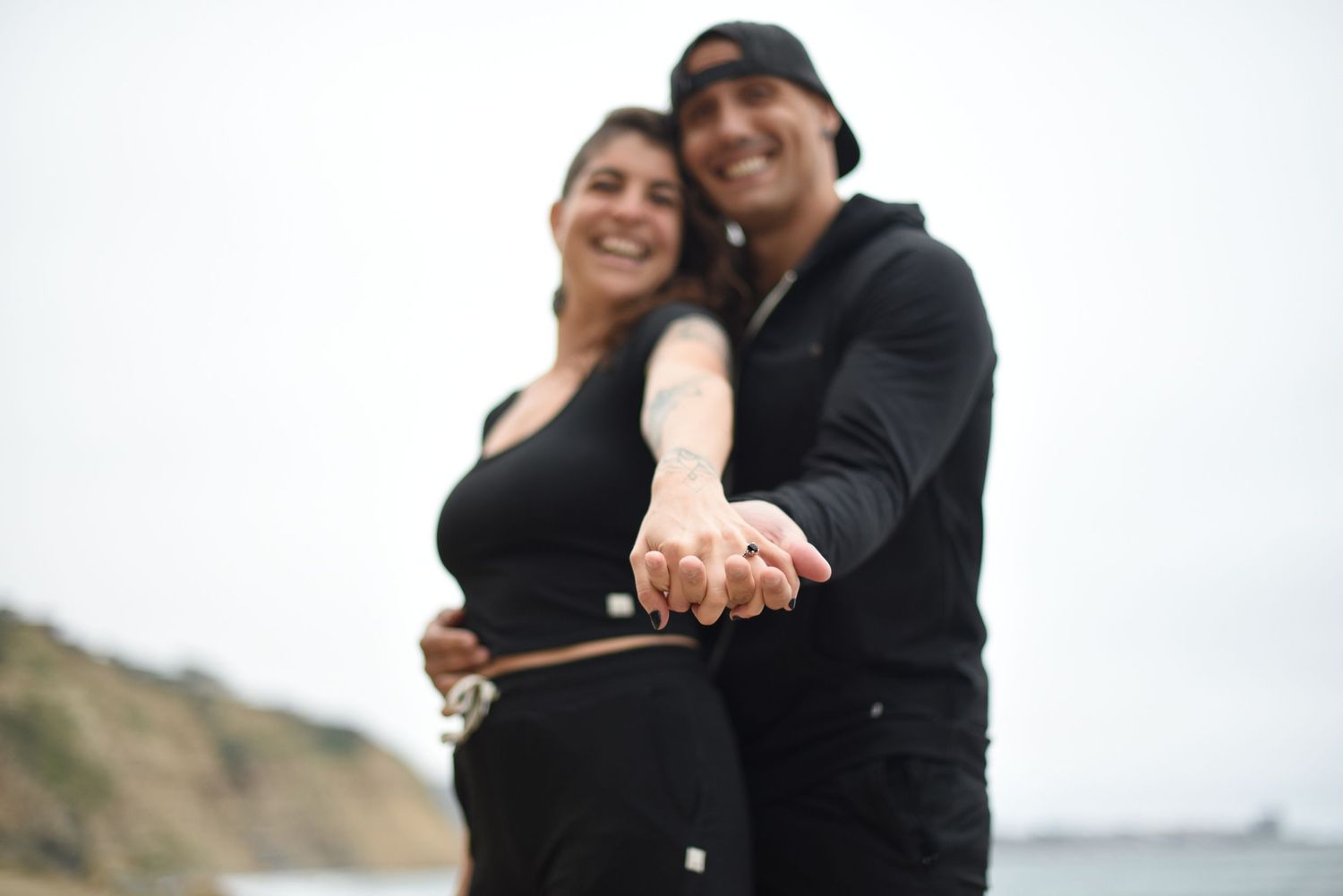 Intimate couple embracing and sharing affectionate moments by the ocean.