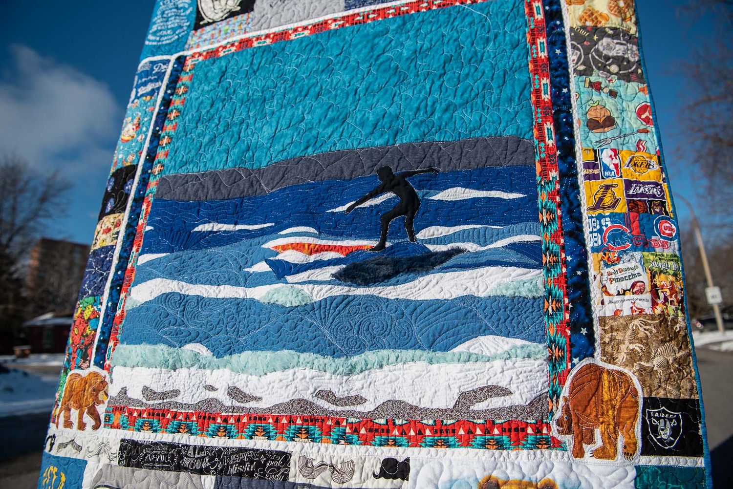 Art Memory quilt by This Splendid Chaos showing a boy surfing, all made with baby clothes.