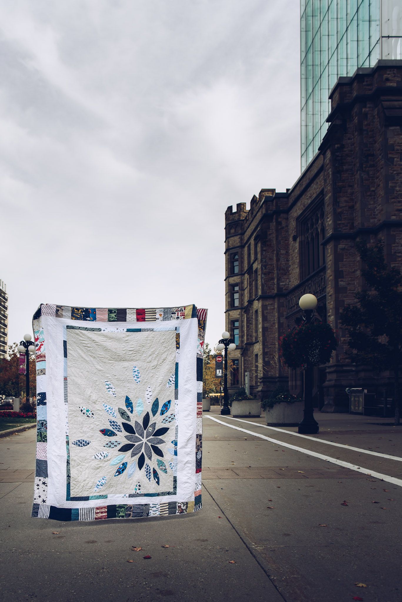 Memory quilt being held up in front of the Canadian Museum of Nature.