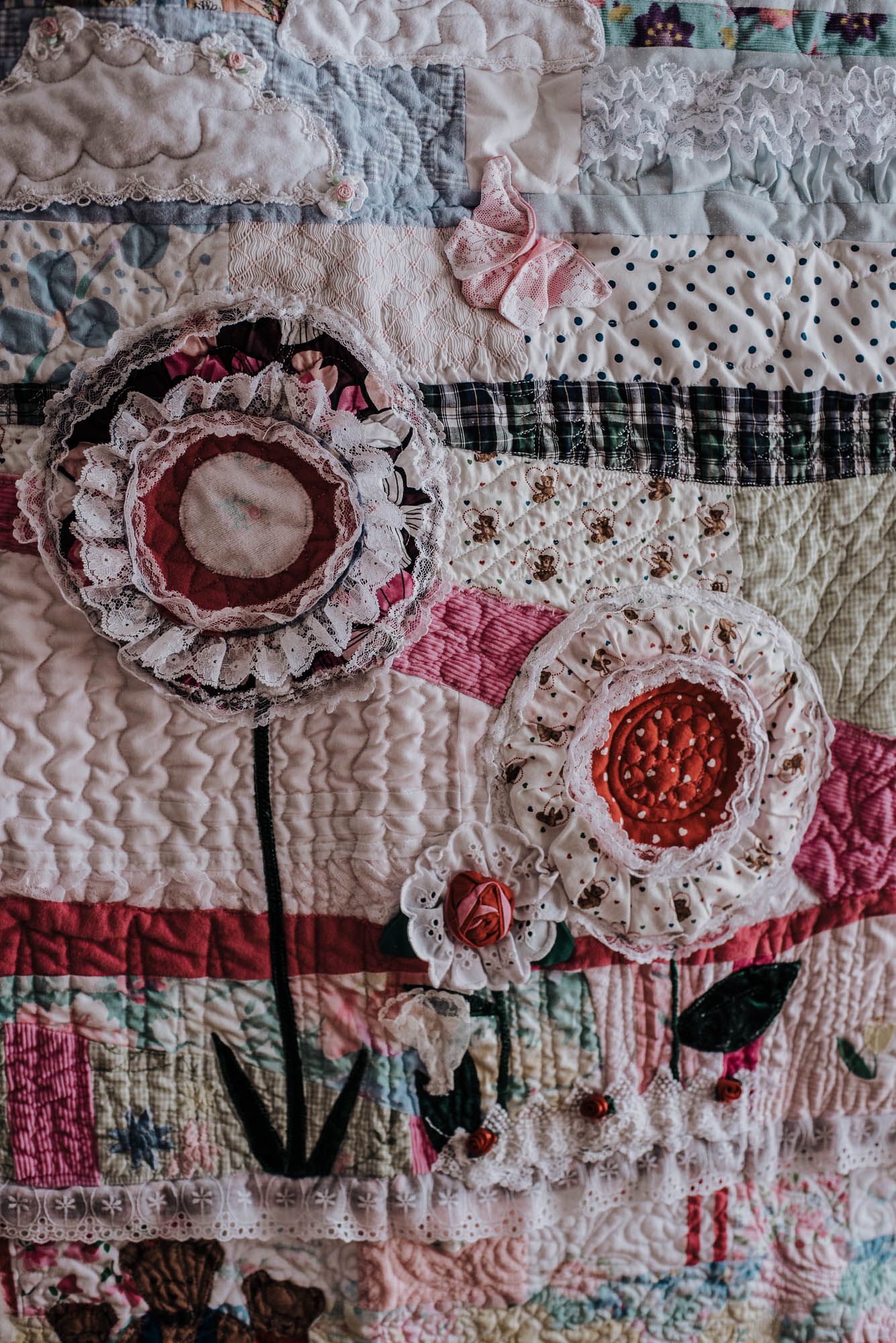 Colourful flowers made from vintage clothing in a memory quilt.