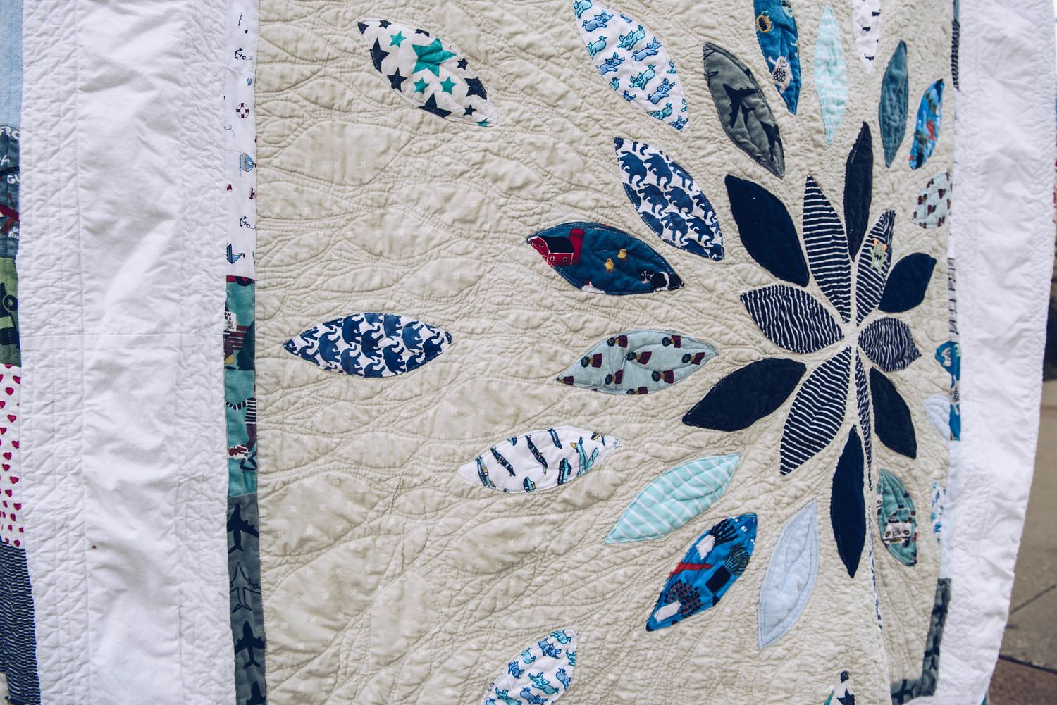 Memory quilt showing a star burst made with clothing.