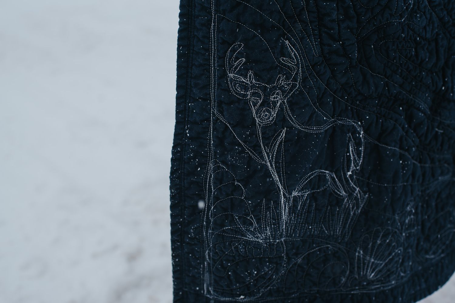 Free motion quilting detail on a memory quilt showing a stag.