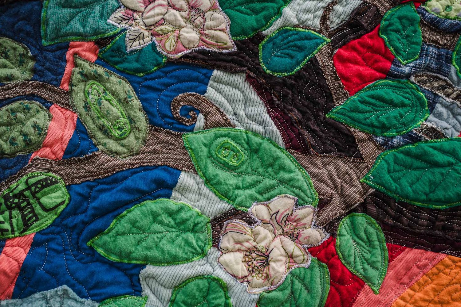 Free motion quilting details on a memorial quilt showing a safety pin.