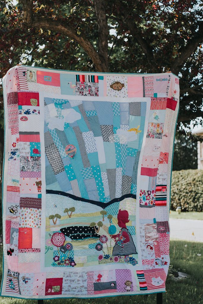 Beautiful memory quilt in mainly pink clothes of a little girl picking flowers.