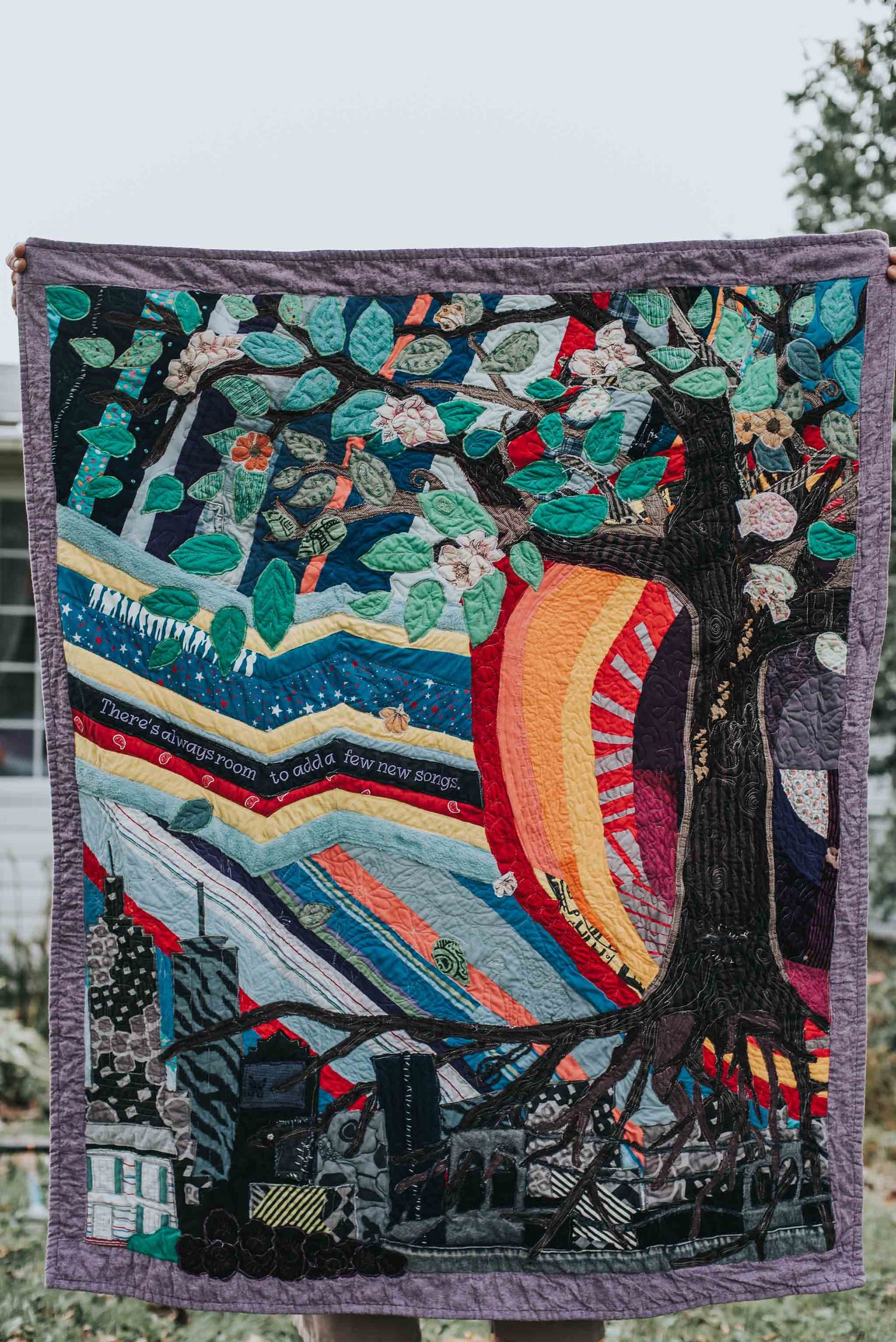 Intricate memory quilt showing a tree with an orb behind it and the NY city skyline below.