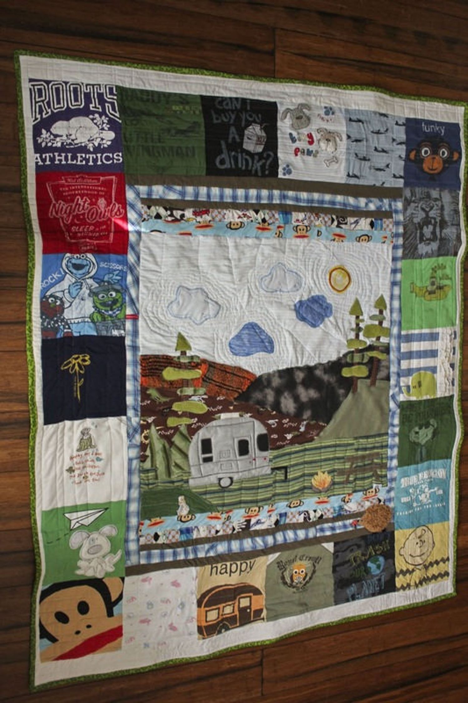 Memory quilt made from clothes showing an airstream trailer with a background of forest.