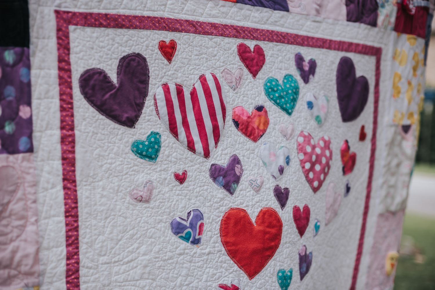 Quilted hearts on Kona white fabric in a memory quilt.