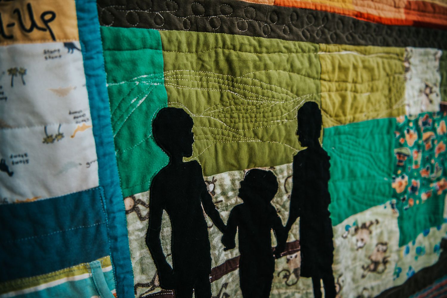 Silhouette made from baby clothes from an image of 3 brothers and incorporated into a memory quilt.