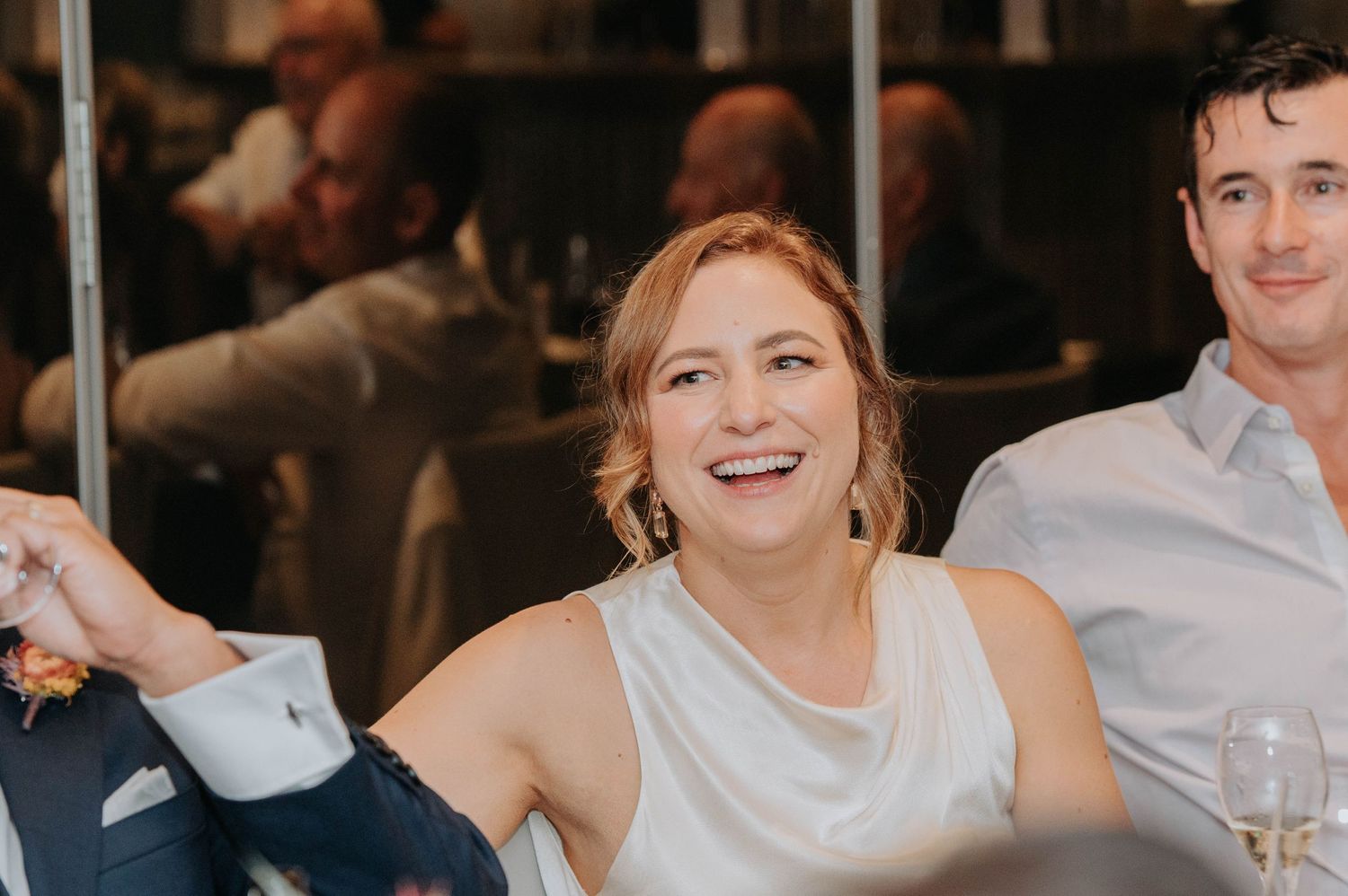 Wedding guest smiles joyfully during reception celebration.