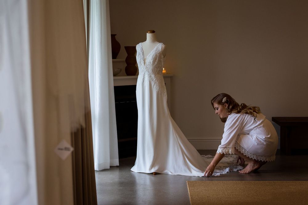 The Brides Wedding dress on a mannequin at Lancemore Milawa as the Bride smoothes out the dress.