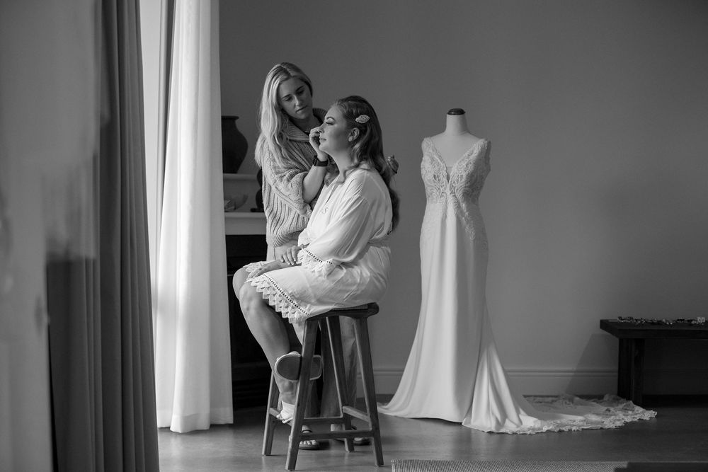 Bride in her makeup session at Lancemore Milawa with her wedding dress in the background
