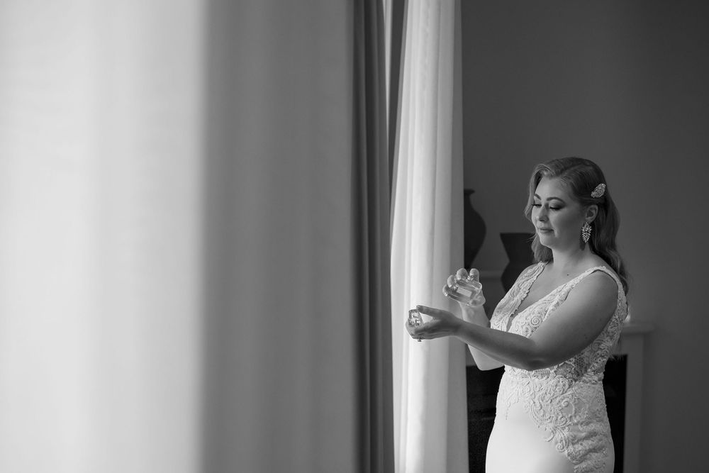 Bride in her wedding dress putting on perfume before her ceremony at Lancemmore in Milawa