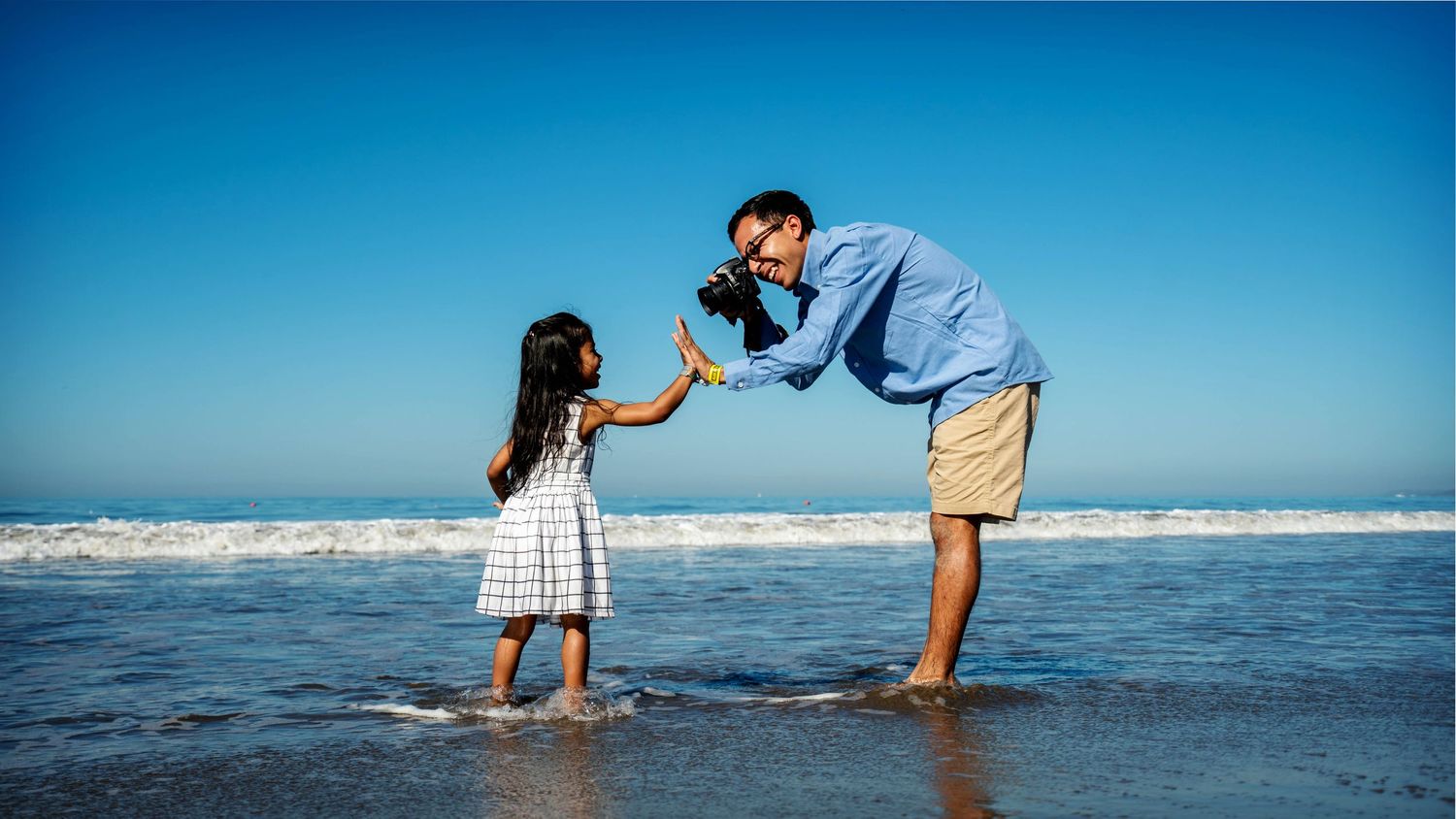 Two people playing in the ocean waves at the beach.