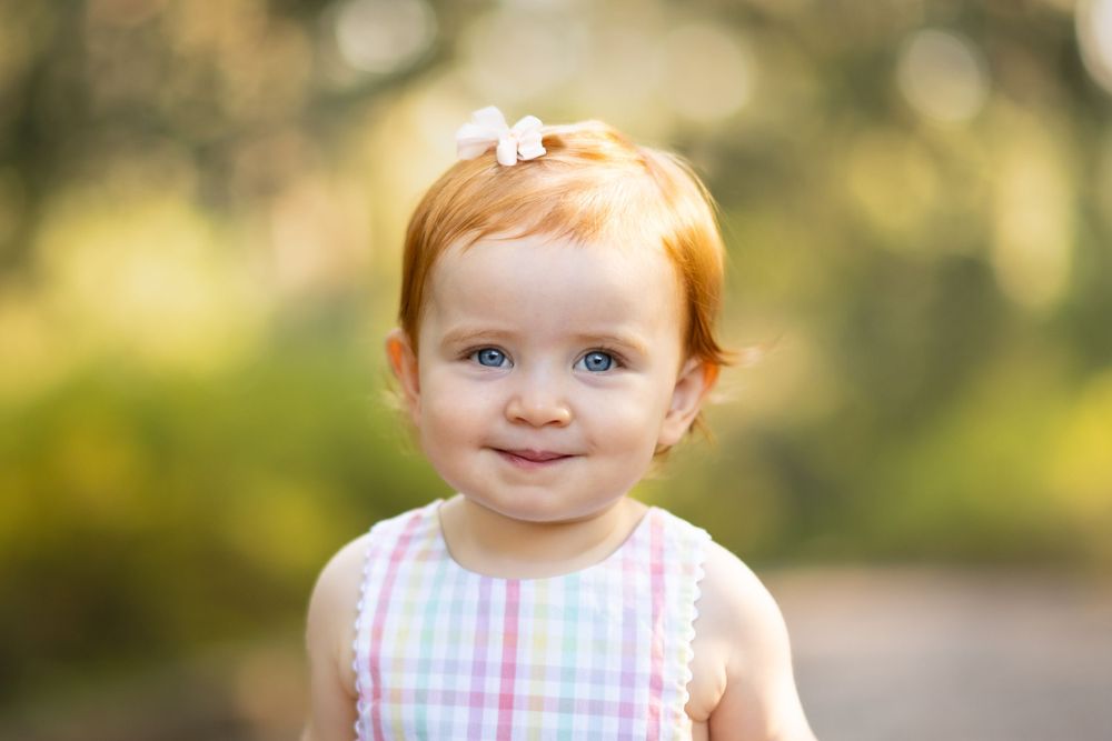 Beautiful redheaded, blue-eyed toddler captured by a Tallahassee photographer, highlighting a joyful portrait
