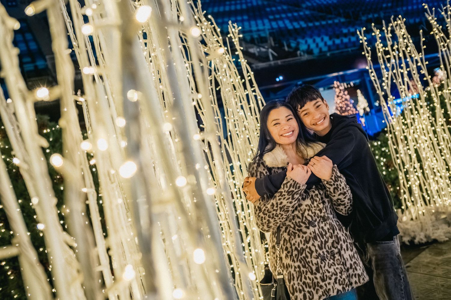 A romantic moment among glowing LED light installations at night.