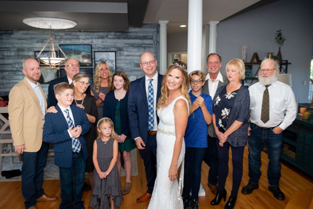Large wedding party gathering in modern venue with blue walls and elegant lighting.