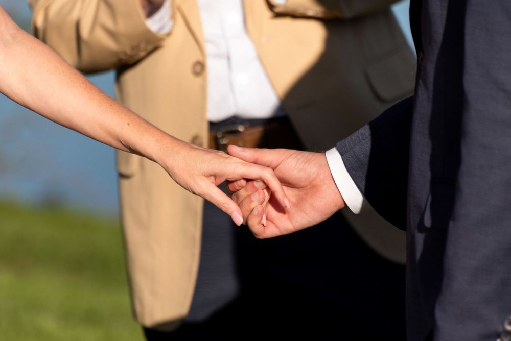 Close-up detail shot of formal wedding attire in earth tones and navy blue.