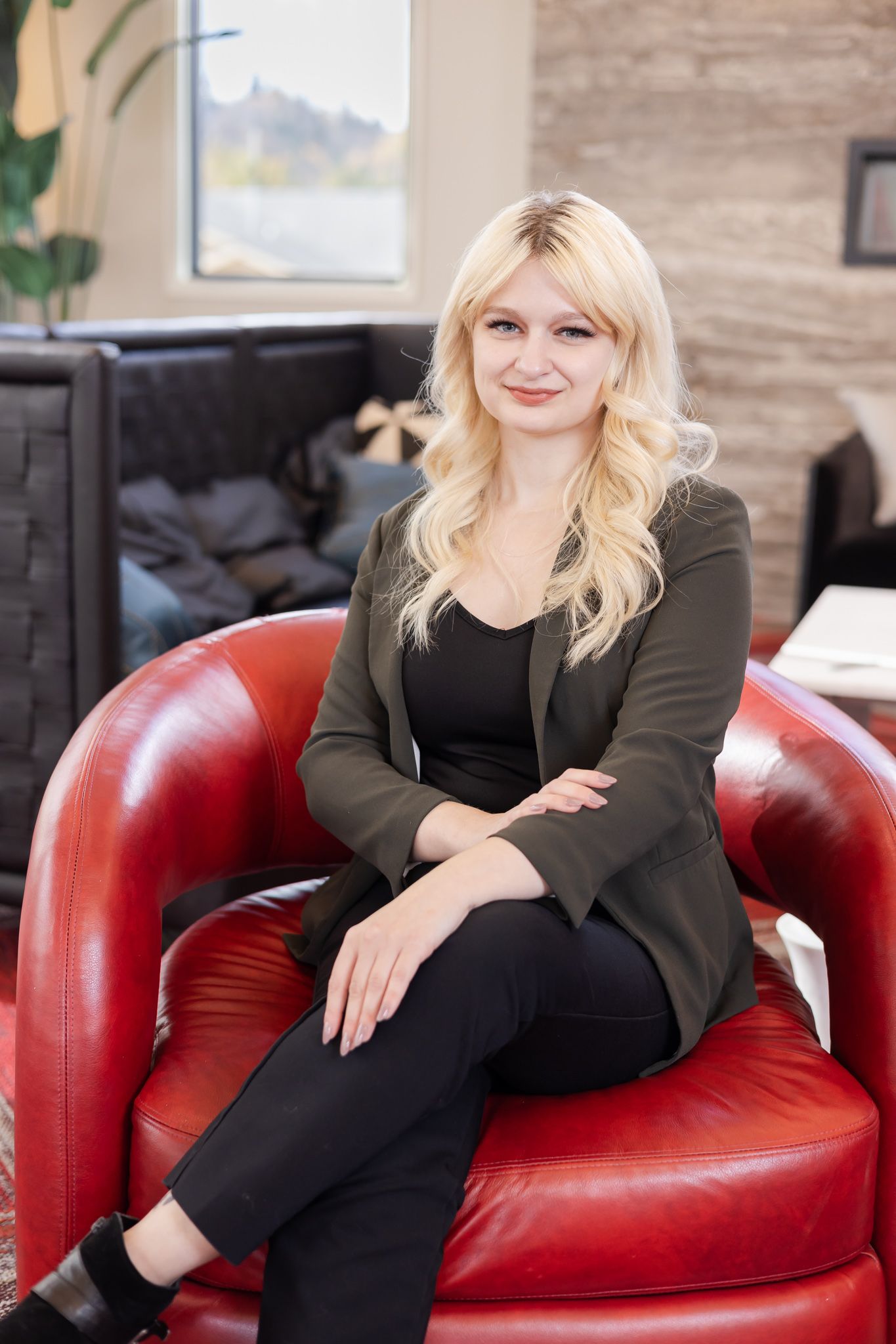 Lacey keller williams real estate agent in greater seattle area, blond woman sitting on red chair for headshot