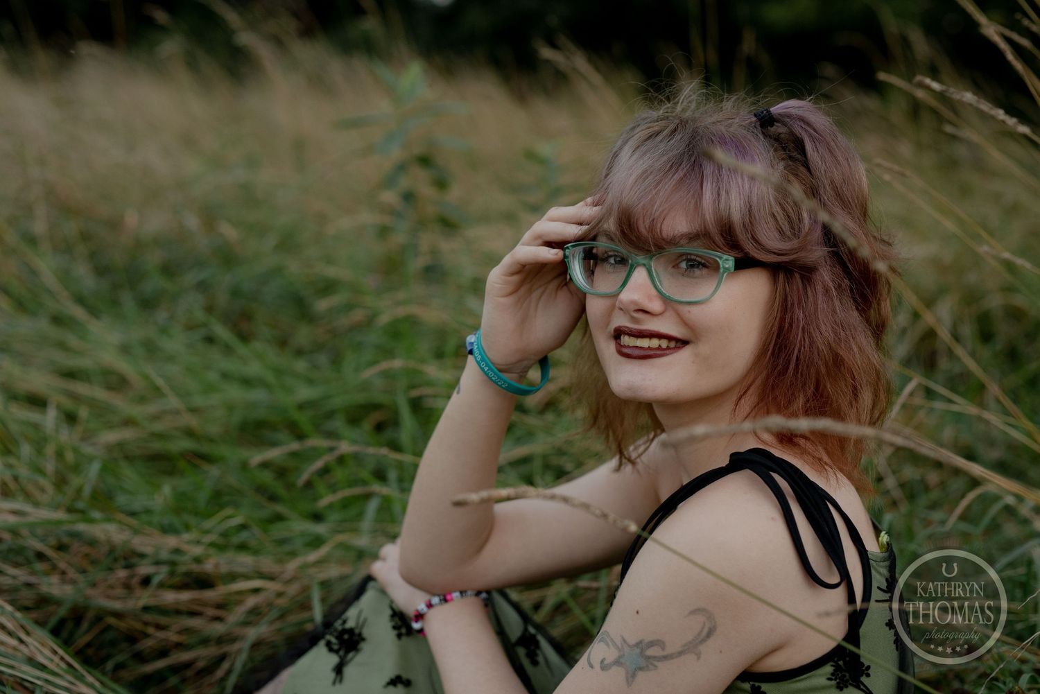 Artistic outdoor portrait with vintage dress and glasses in natural setting.