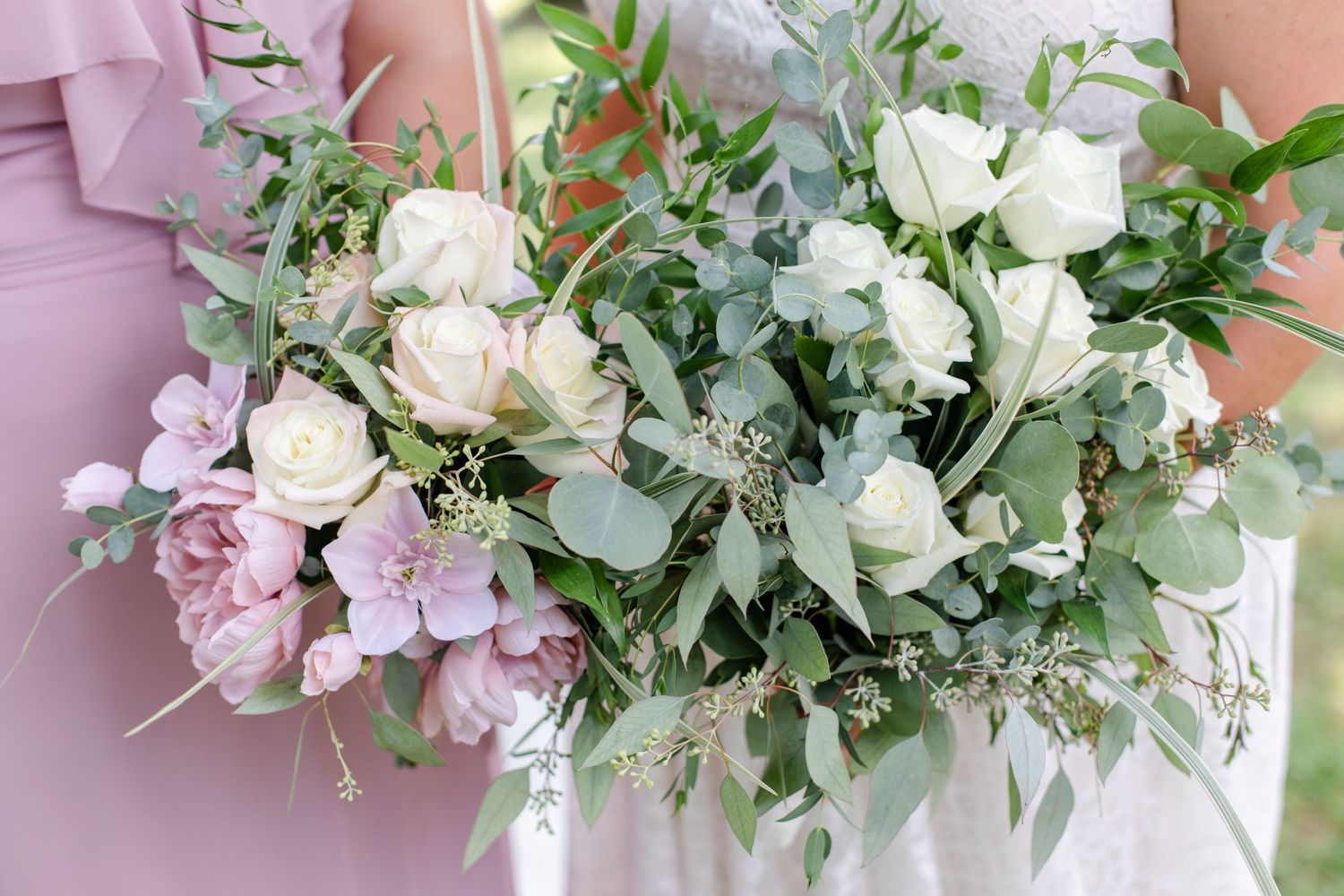 Elegant pink and white floral wedding bouquets with roses and greenery arranged in a row.