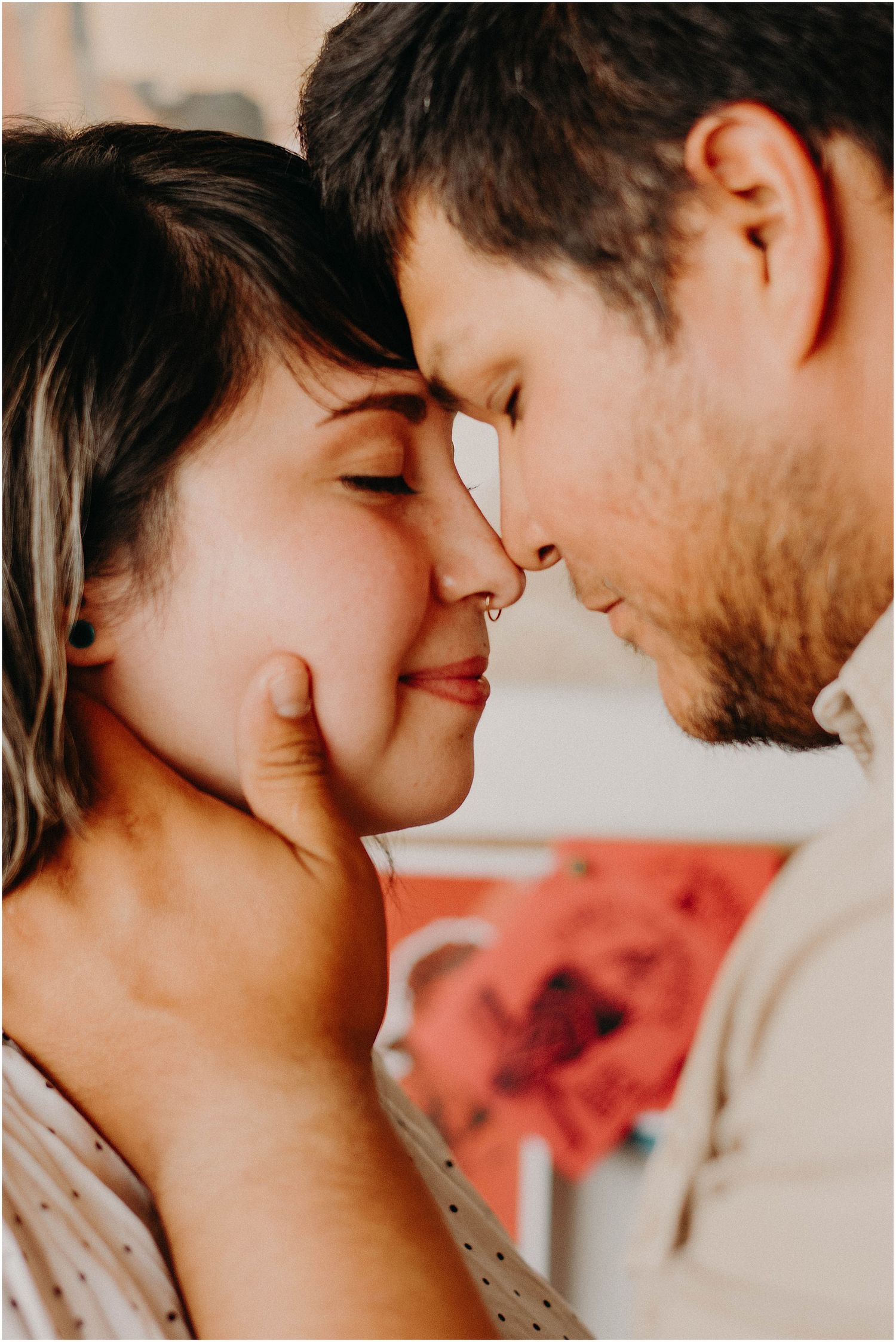 Intimate close-up of a couple sharing a tender forehead touching moment in warm lighting.