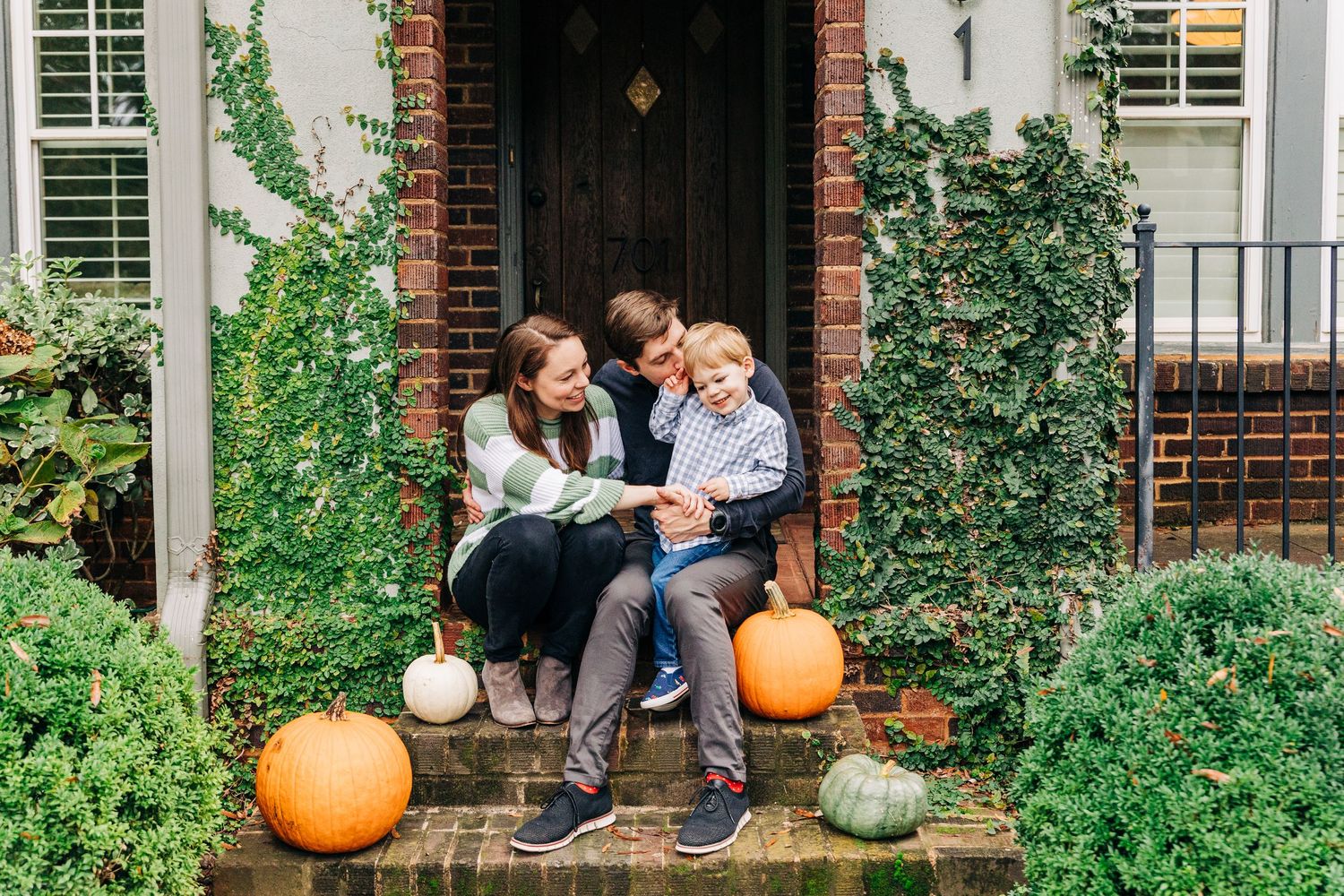 Family of 3 snuggling on their front porch in Charlotte, NC