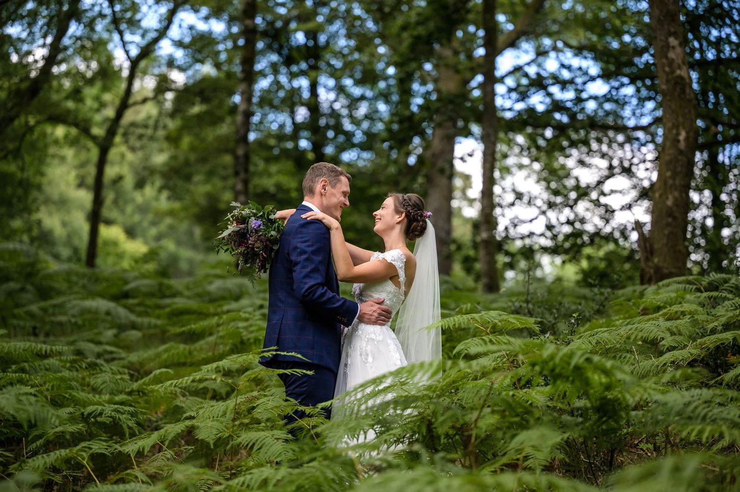 Bride and groom in woods near Windermere in Lake District