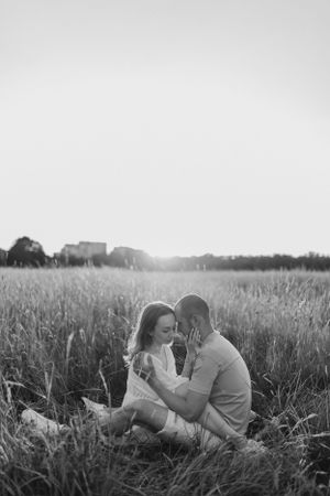 A black and white intimate portrait in a meadow with soft natural lighting.