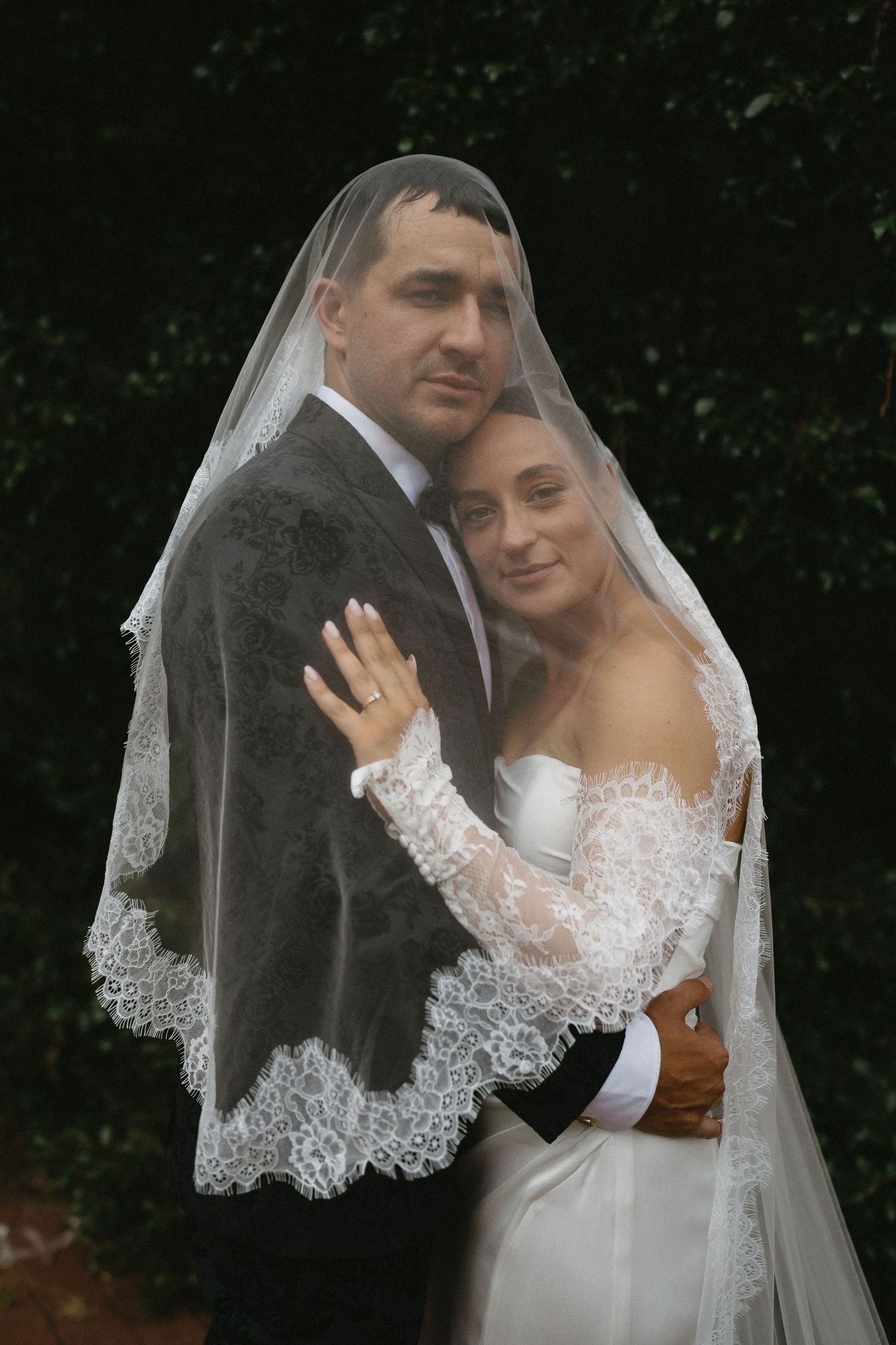 A romantic wedding photoshoot sequence shows the bride and groom embracing under a delicate lace veil in a garden setting.