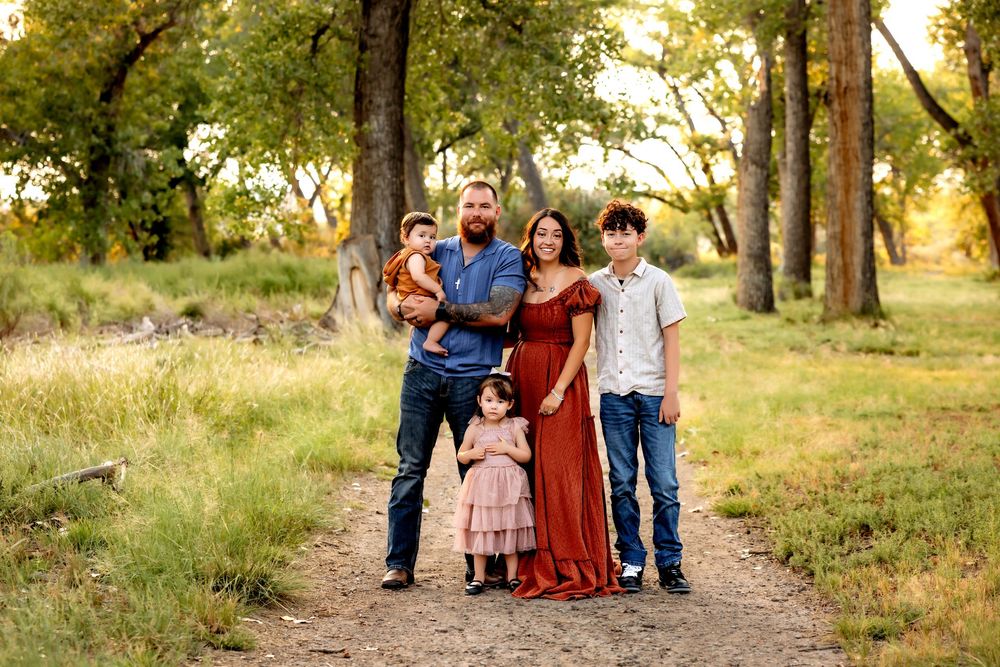 A group walks together on a tree-lined path during golden hour in a natural outdoor setting.
