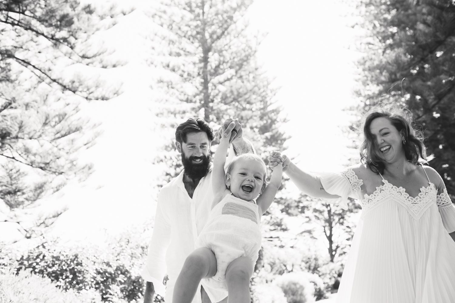 Joyful family moment captured in black and white against snowy winter backdrop.