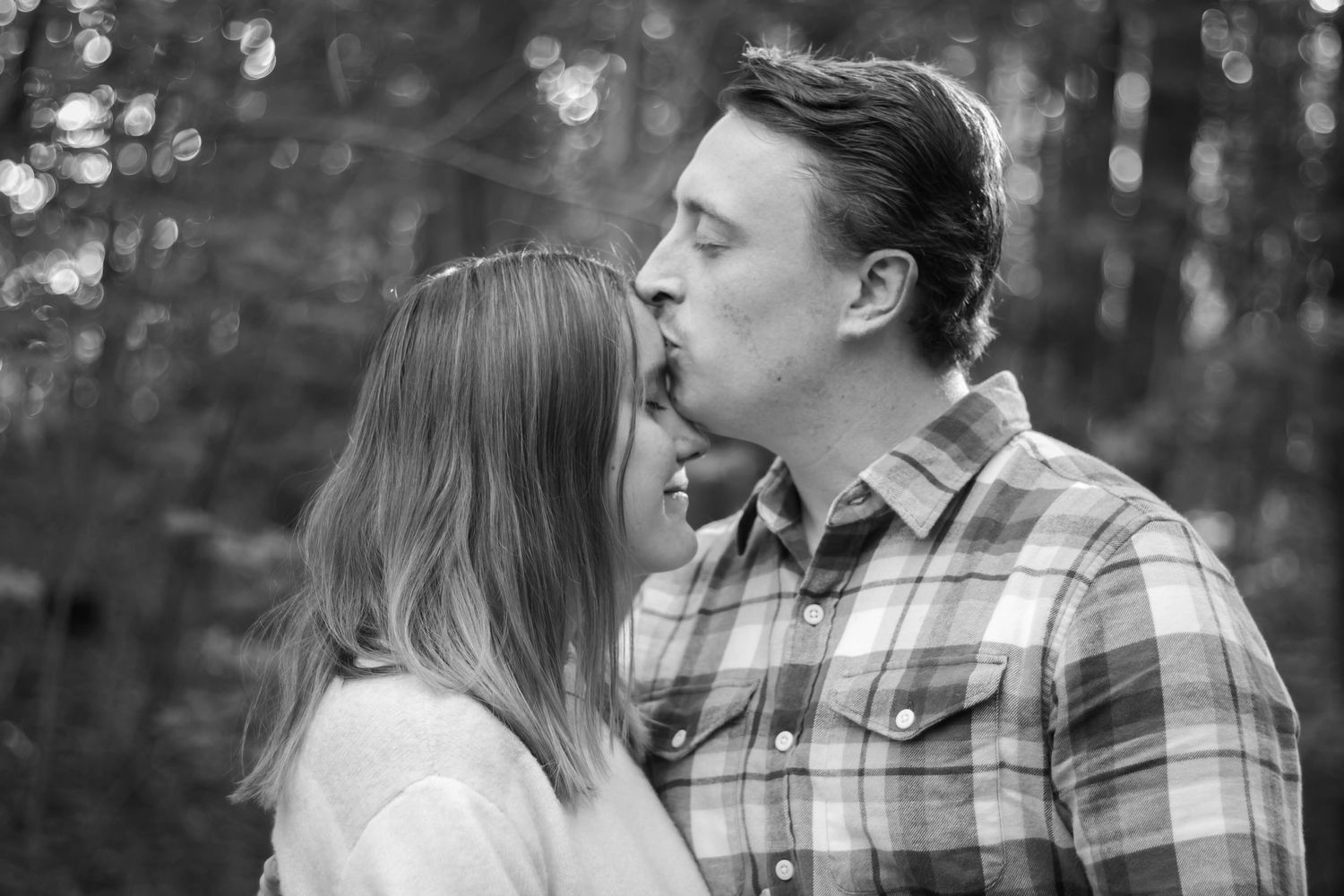 Black and white photo of dad kissing mom's forehead