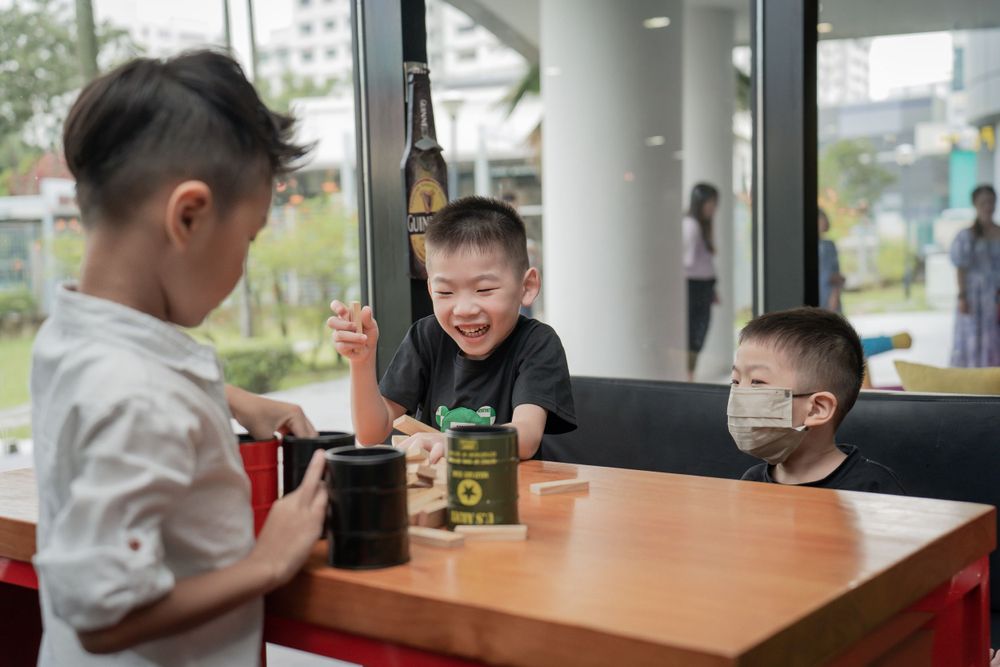 Three children sharing snacks at a casual restaurant table.