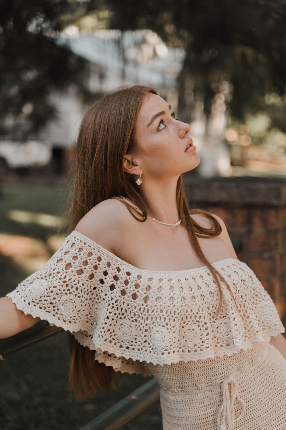 Detailed shot of off-shoulder crochet dress with intricate ruffle detail in natural lighting.