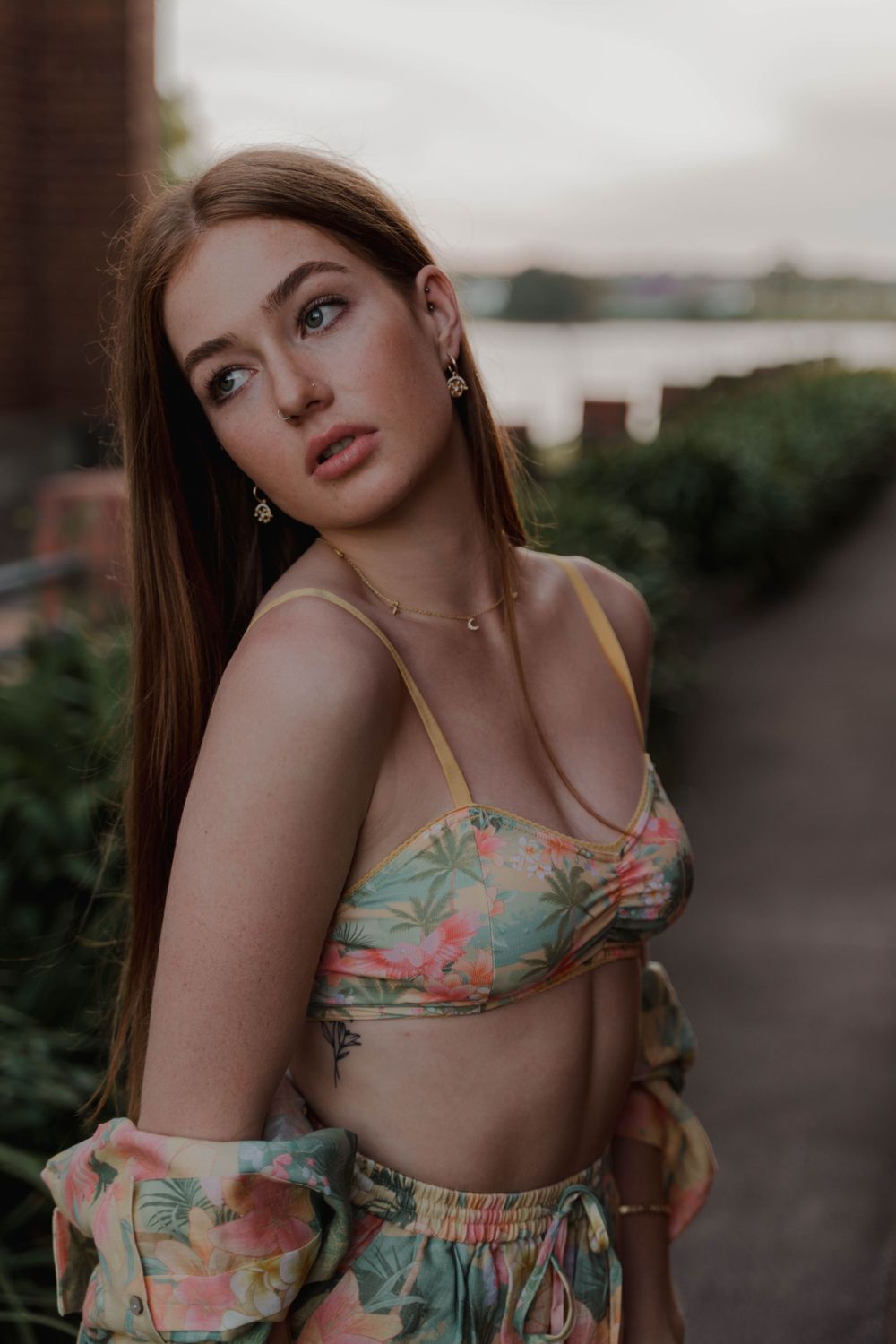 A tropical print swimwear set with matching shirt captured at golden hour by the water.