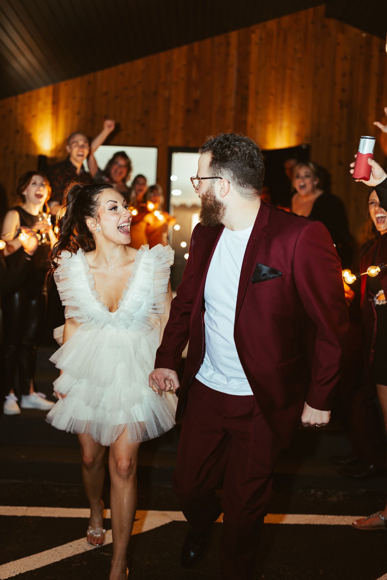 Joyful couple dancing at wedding celebration in rustic venue.