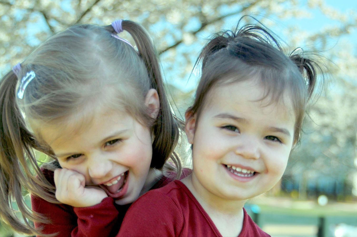 little girls laughing outside with spring flowers