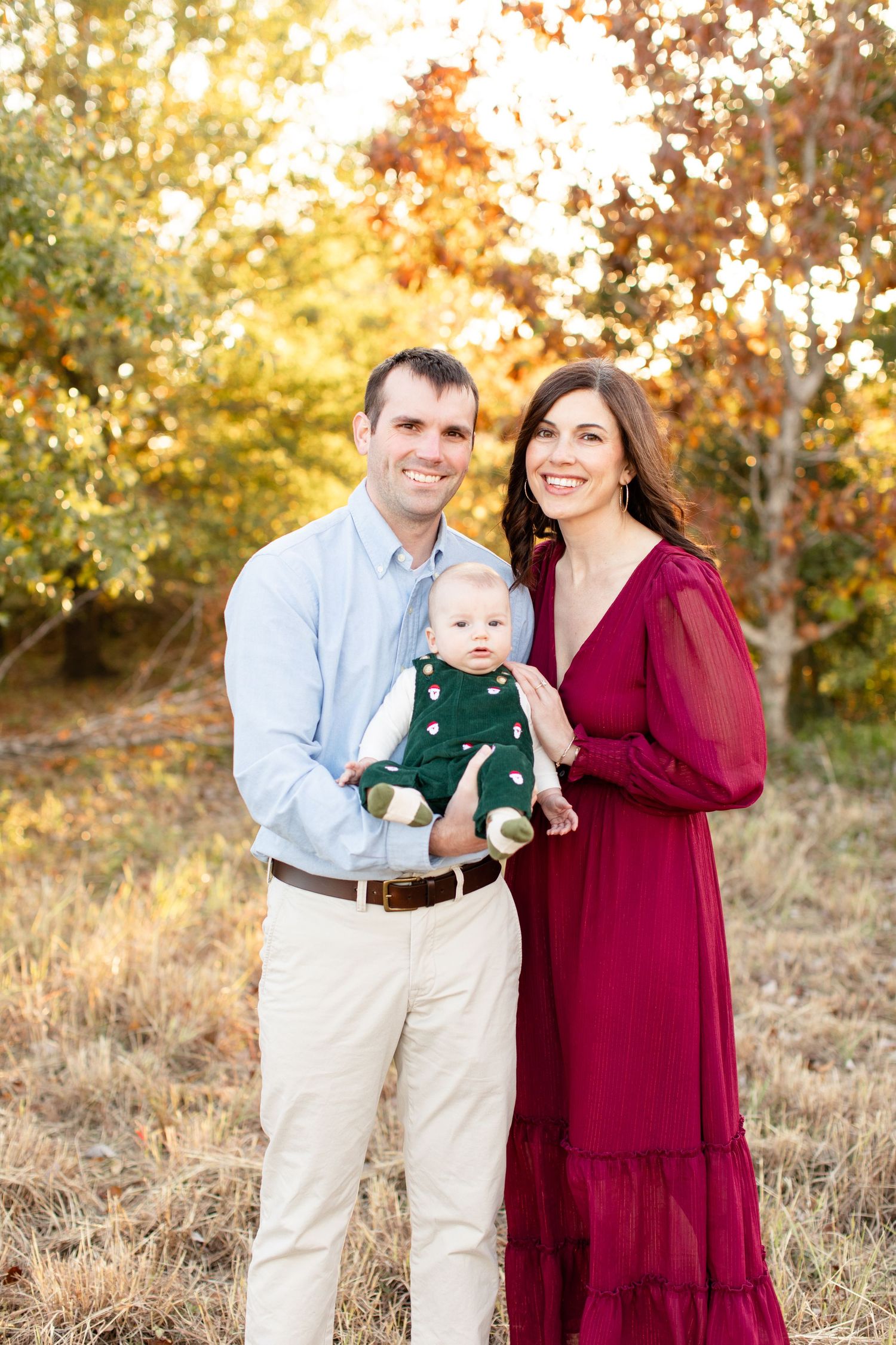 Outdoor family portrait with fall foliage in golden sunset light.