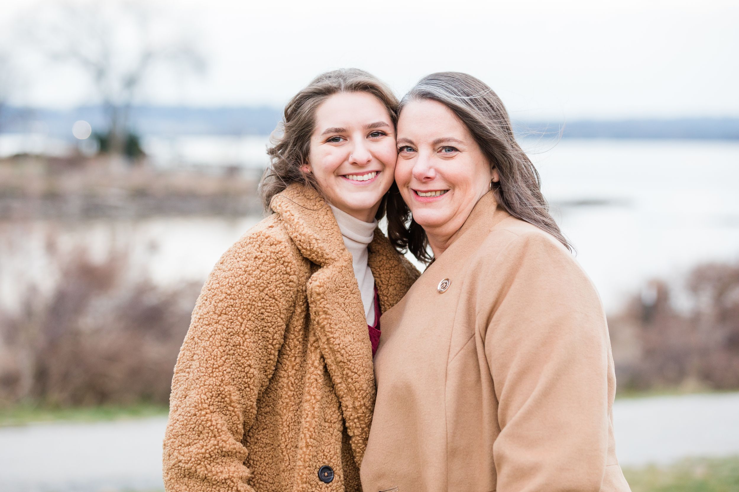 Mom and daughter posing in Old Town Alexandria waterfront in winter