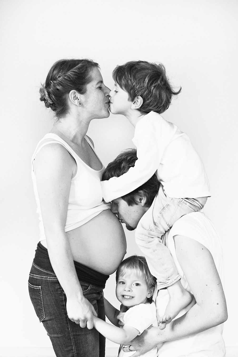 Schwangere Mutter mit dem Partner, beide schauen liebevoll auf den Babybauch.
Kinder, die sanft den Bauch der Mutter berühren – symbolisch f