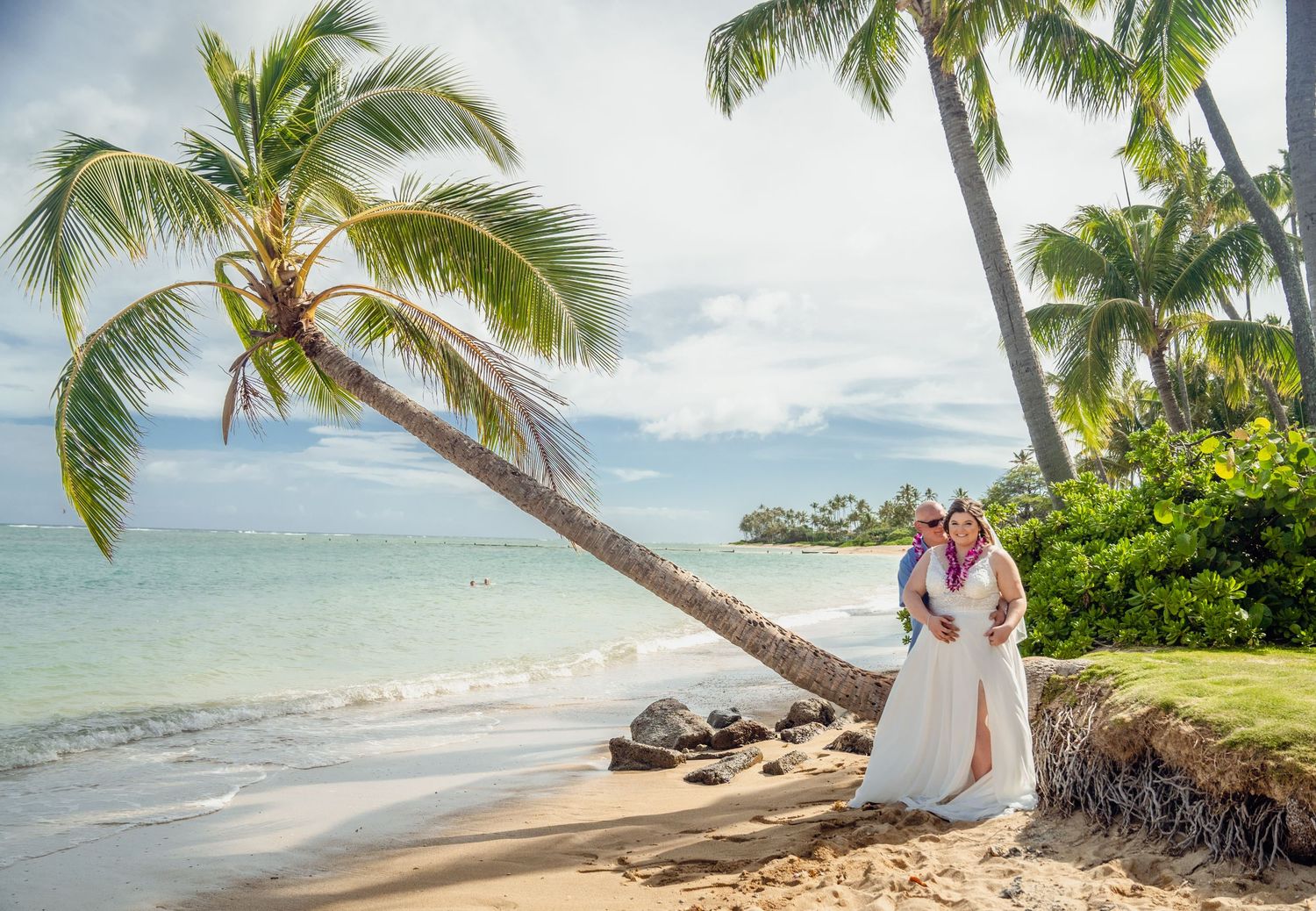 Beachside wedding ceremony with palm trees and ocean views on a tropical Hawaiian shore.