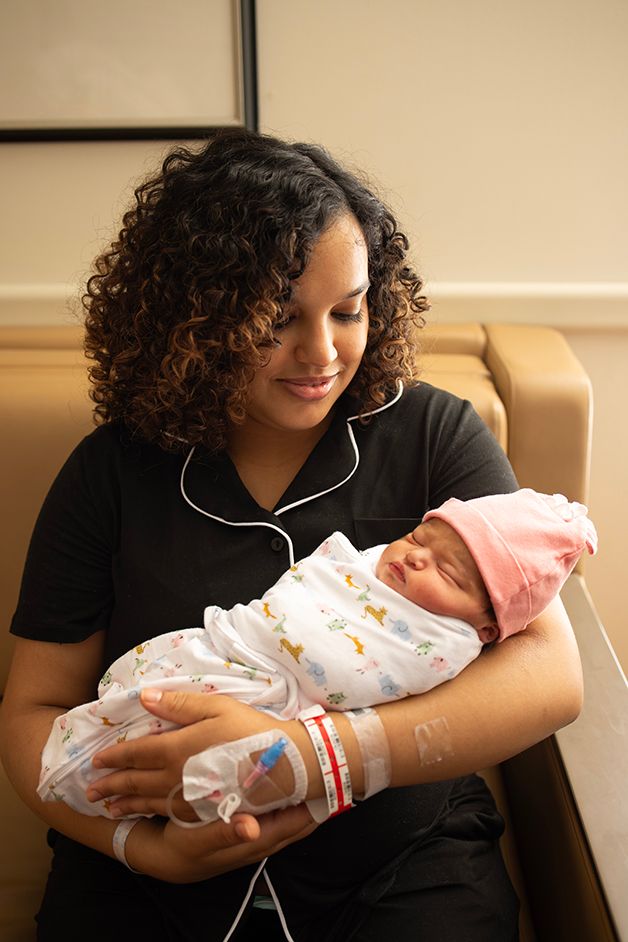 Newborn baby girl being held by her mom less than 24 hours after birth,.