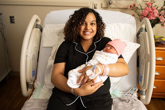 New mom smiling holding her first born baby girl.