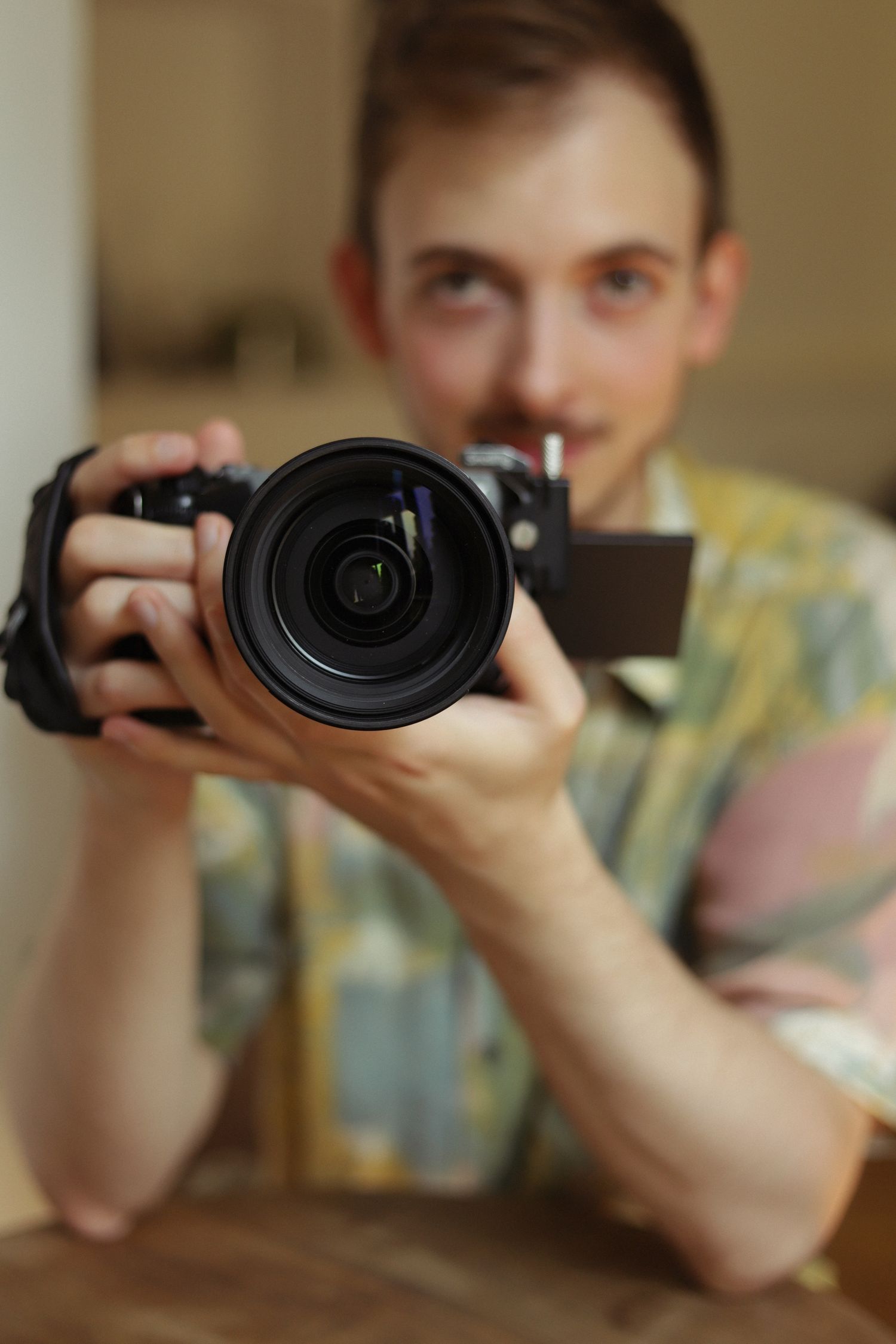 Close up shot of person holding professional camera with large lens.