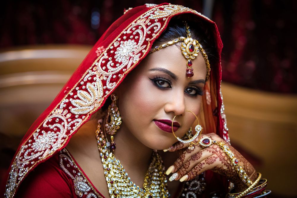 Close-up portrait highlighting traditional Indian bridal makeup and jewelry.